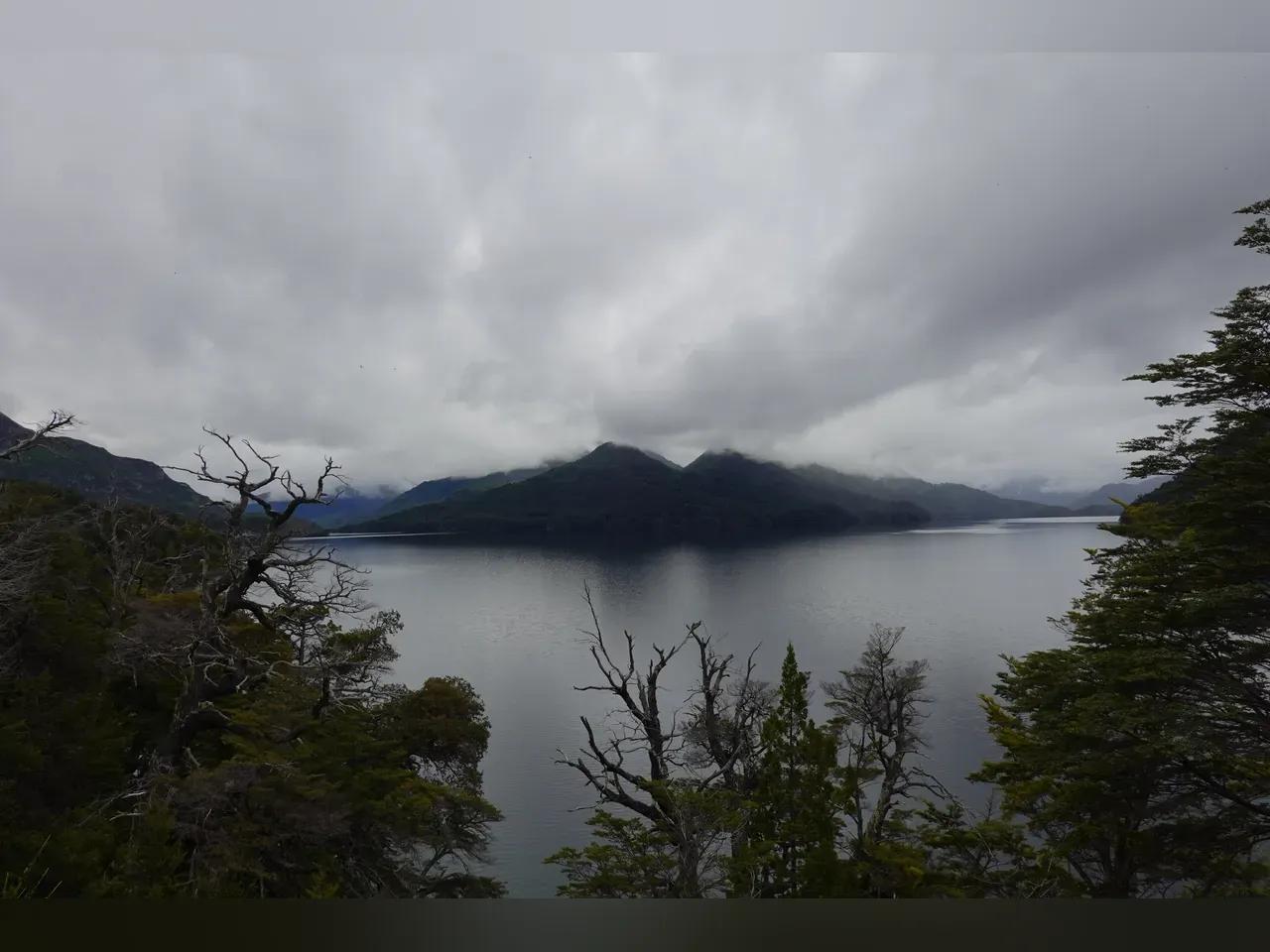 Wolkenverhangener Himmer, großer See in Patagonien, im Hintergrund Berge