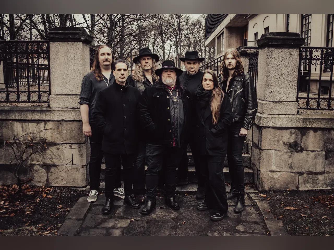 Bandmitglieder von Year of the Goat stehen bei trübem Wetter vor einer Toreinfahrt