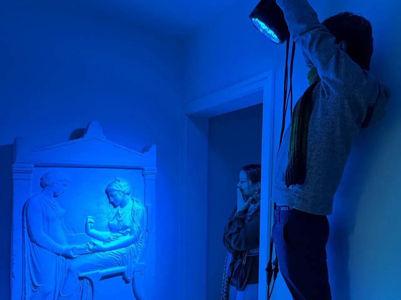 Ein antikes Relief wird mit Strahlern blau beleuchtet