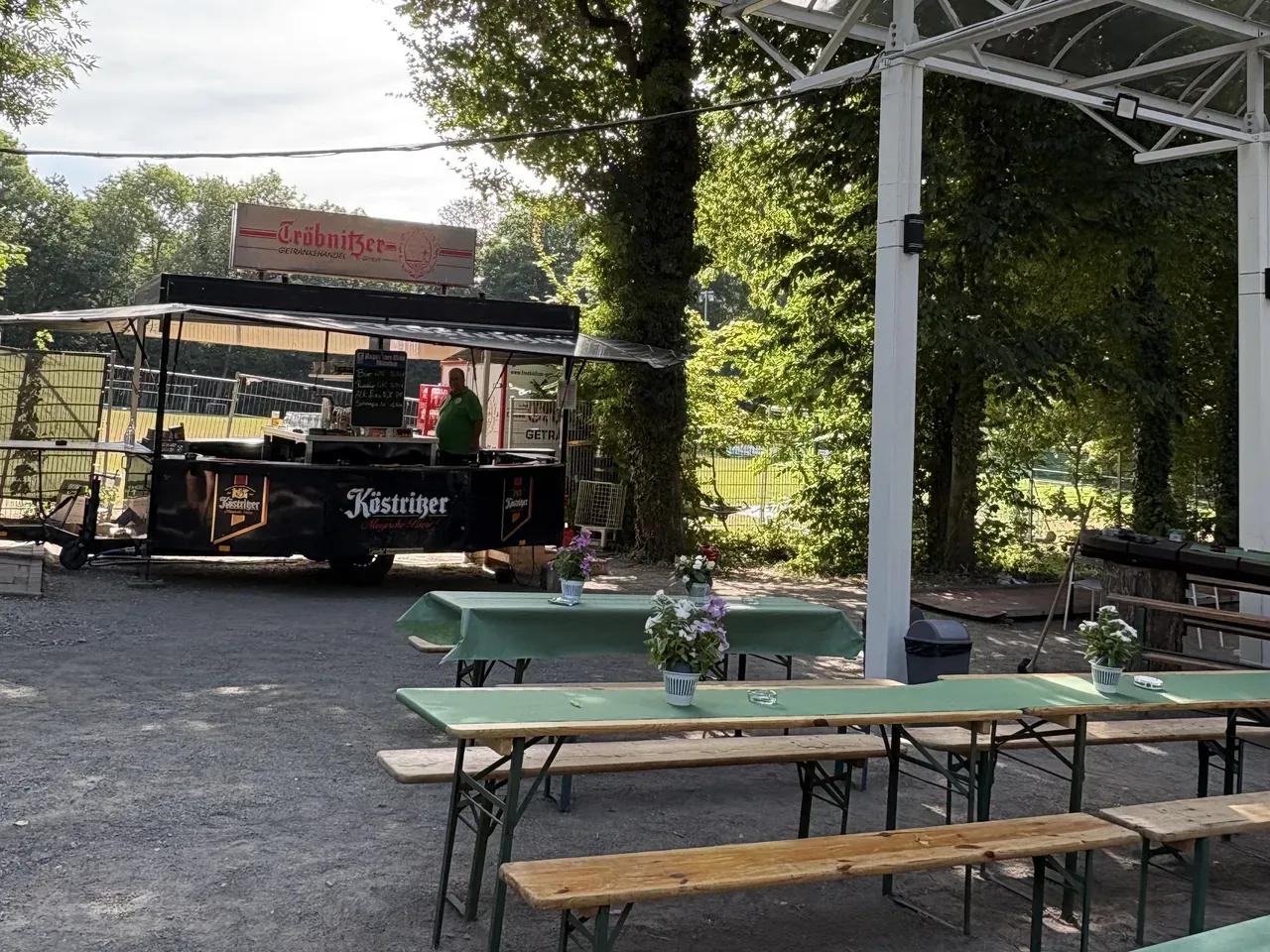 Platz mit Biertischen und Getränkewagen