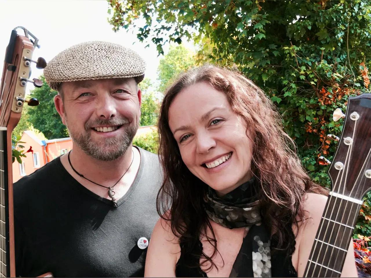 Die zwei Musiker:innen von La Belle Vie mit Gitarren